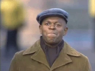 Smiling man in a newsboy cap applauding outdoors