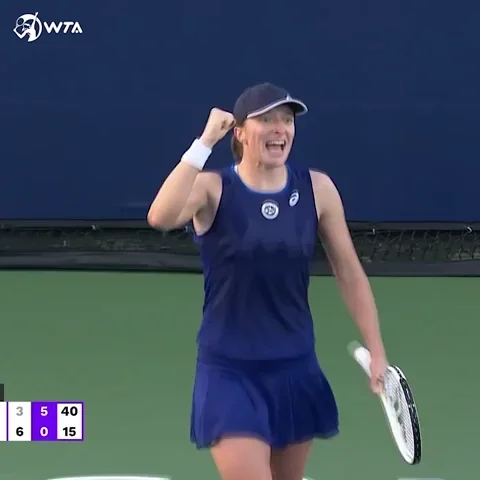 Smiling tennis player raising a fist after winning a point